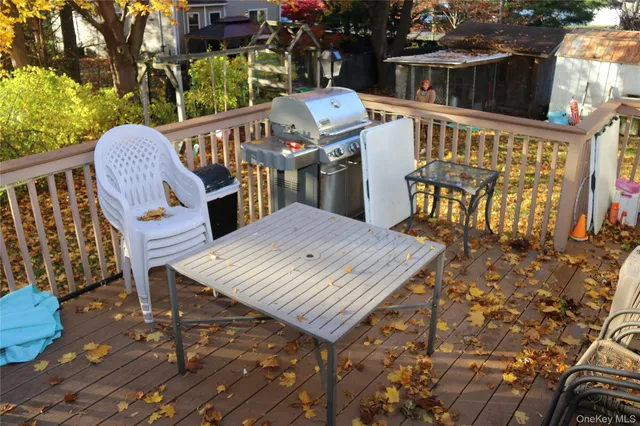a view of a patio with table and chairs with wooden floor and fence