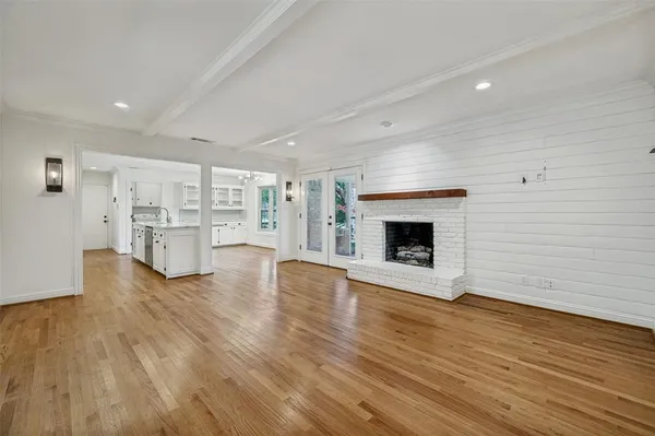 a view of empty room with wooden floor and fireplace