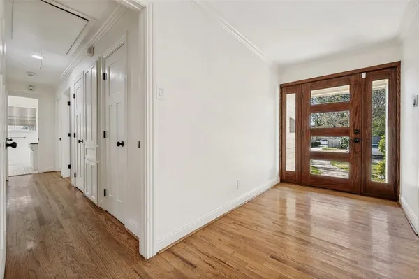 a view of an empty room with window and wooden floor