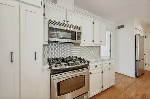 a kitchen with stainless steel appliances white cabinets and a stove