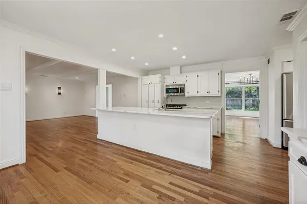 a view of kitchen with wooden floor and electronic appliances