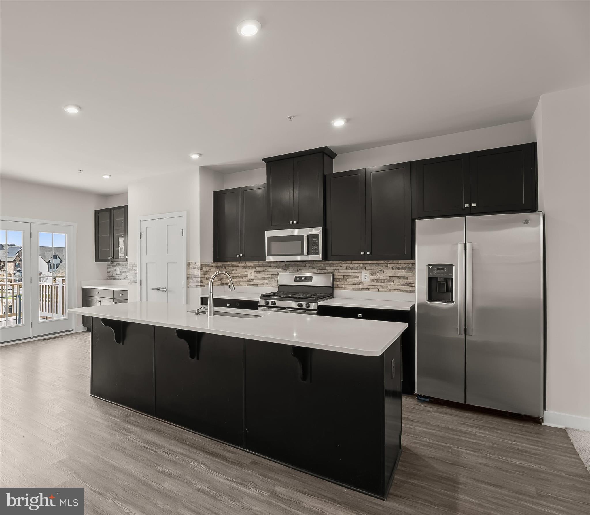 6072 Fallfish Court New Market, MD 21774 - Photo 3 of 78 a kitchen with stainless steel appliances granite countertop a sink a stove a refrigerator and island with wooden floor