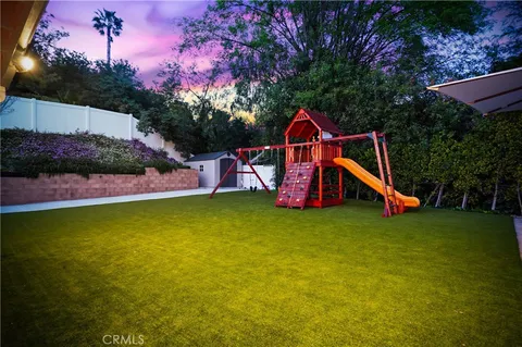 a view of a backyard with table and chairs under an umbrella