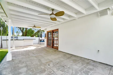 a view of an empty room with a window and kitchen view
