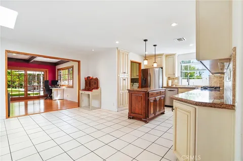 a kitchen with stainless steel appliances kitchen island granite countertop a refrigerator and microwave