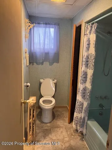 a bathroom with a toilet and a shower