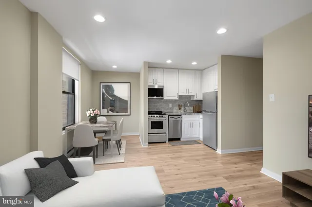 a living room with furniture and kitchen view with wooden floor