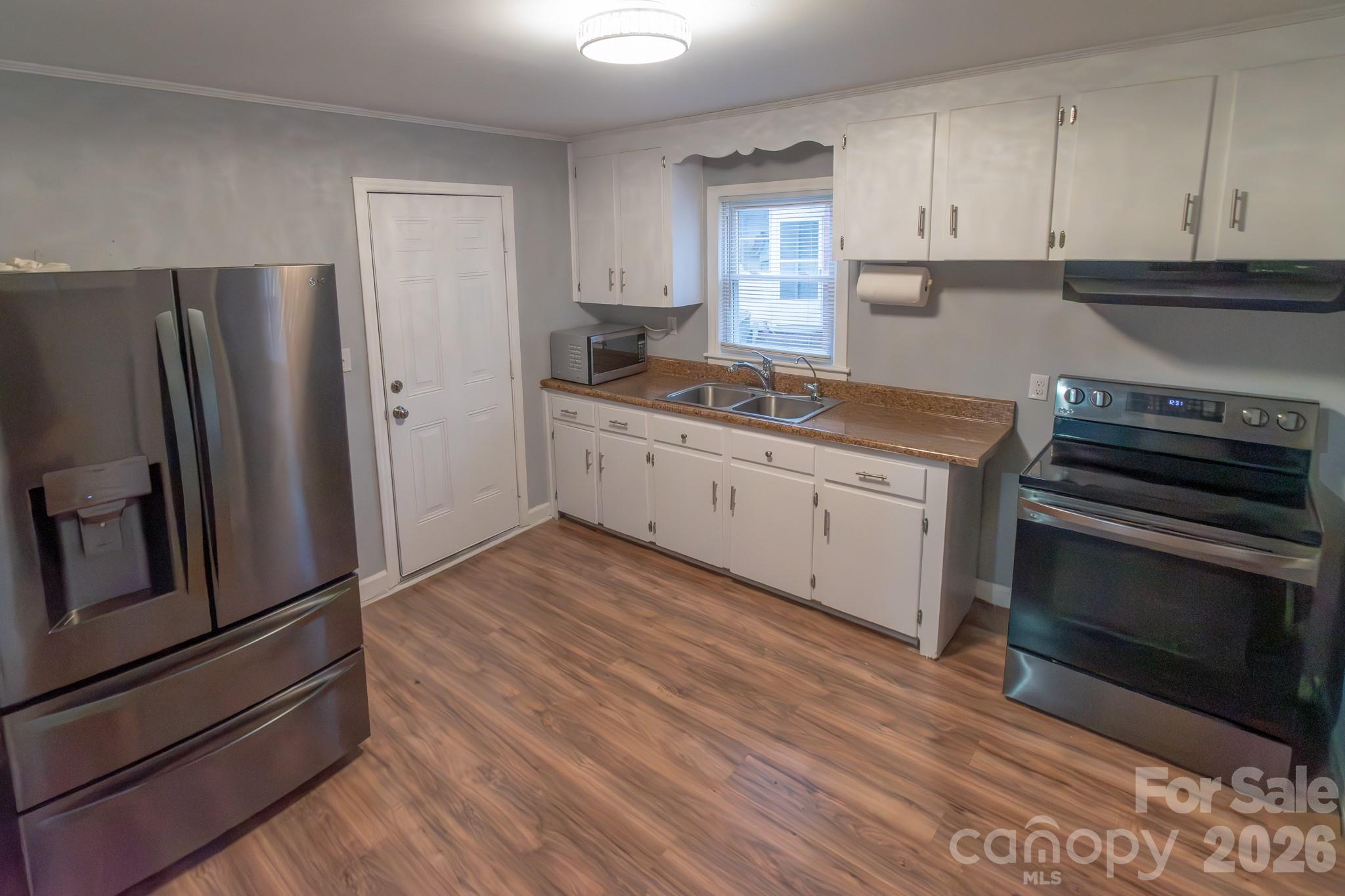 621 Reeves Court Charlotte, NC 28208 - Photo 3 of 11 a kitchen with granite countertop a refrigerator stove and sink