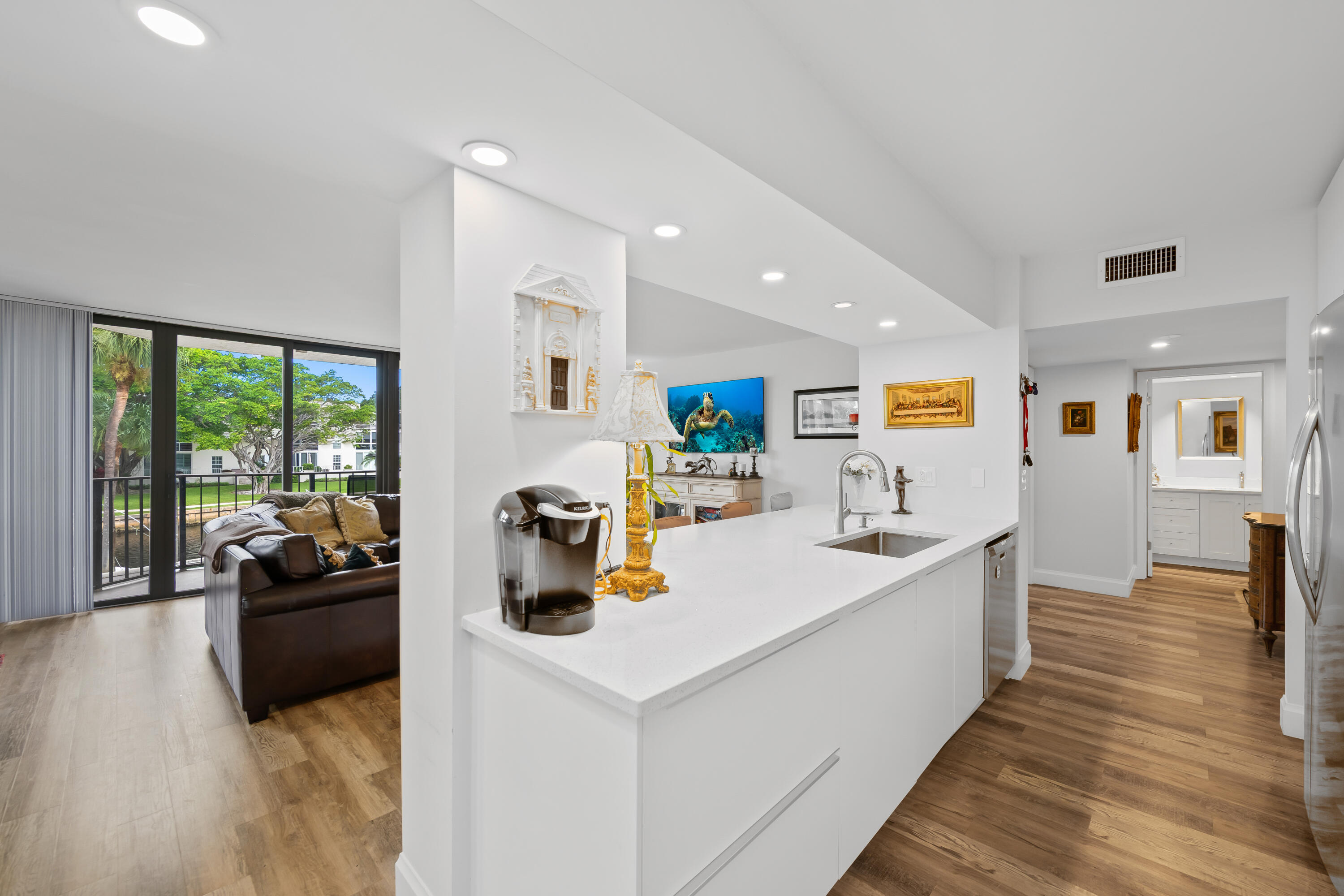 a living room with stainless steel appliances furniture and a large window