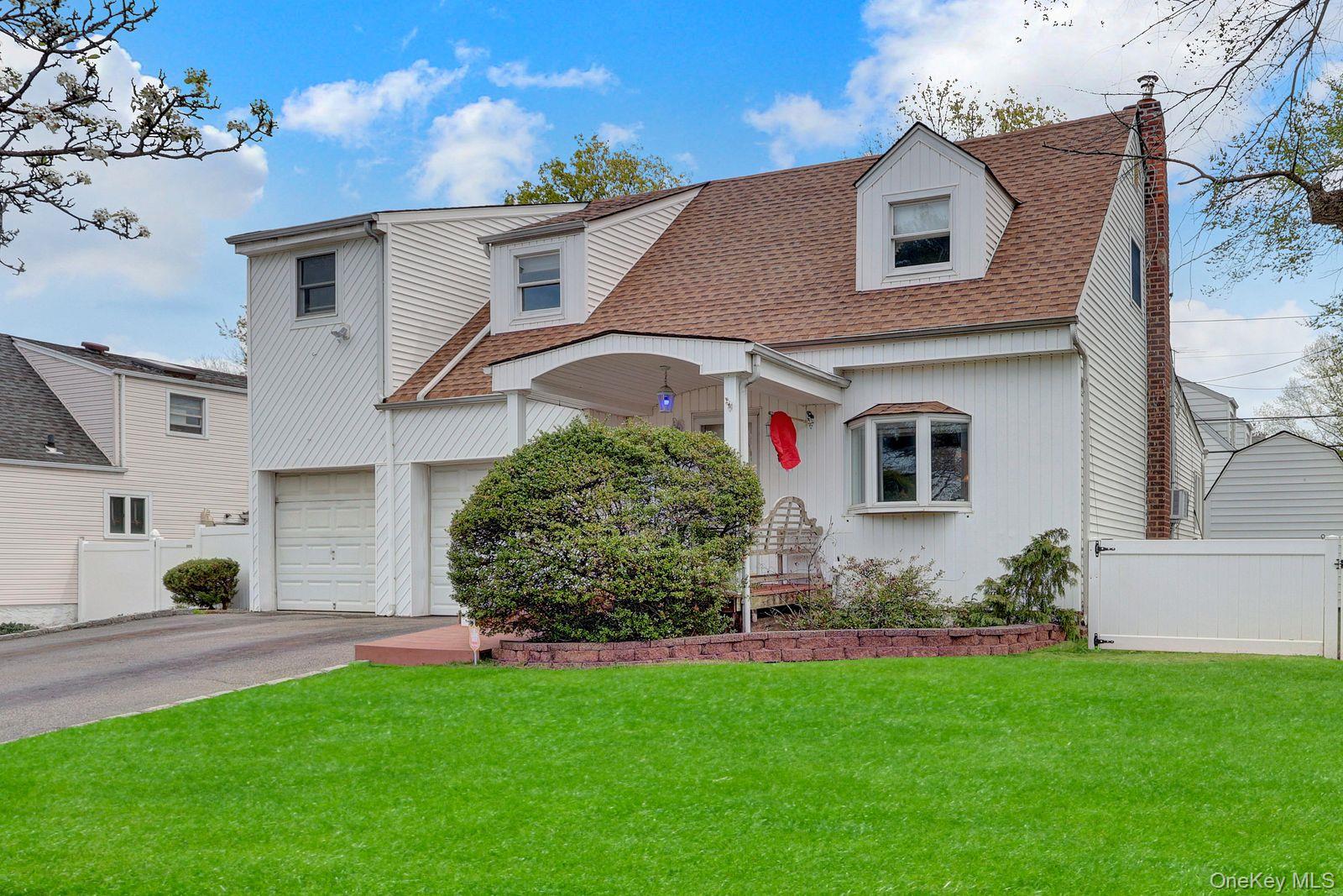 451 North Grove Street Valley Stream, NY 11580 - Photo 1 of 38 a front view of a house with a garden
