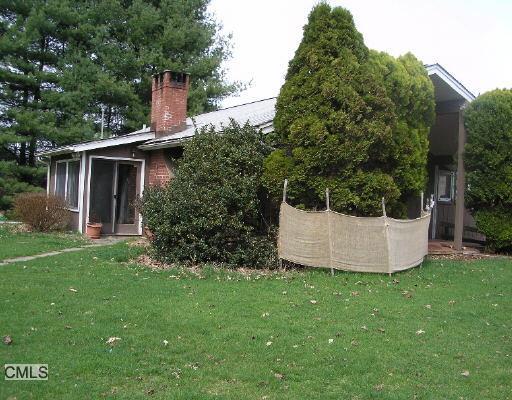 a view of a house with backyard and trees
