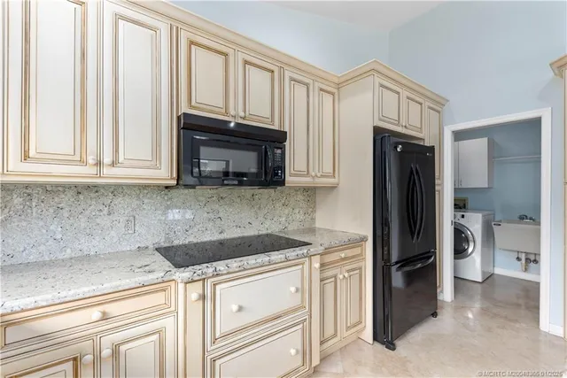a kitchen with granite countertop a refrigerator sink and cabinets