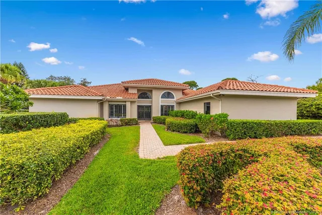 a front view of a house with yard and green space