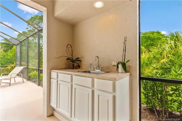 a view of bathroom with a sink and mirror next to a window