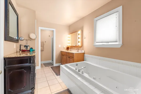 a bathroom with a tub a sink and a mirror