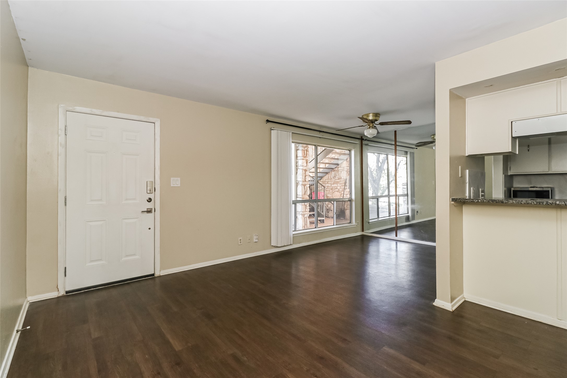 500 East Riverside Drive, Unit 135 Austin, TX 78704 - Photo 5 of 16 Unfurnished living room with dark wood-style floors and a ceiling fan