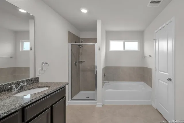 a bathroom with a granite countertop sink a toilet and shower