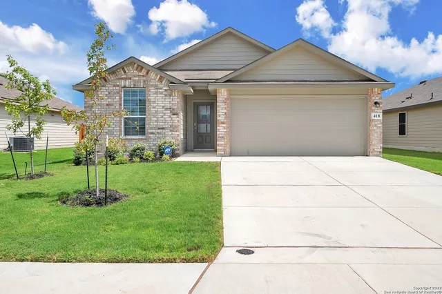 a front view of a house with a yard and trees