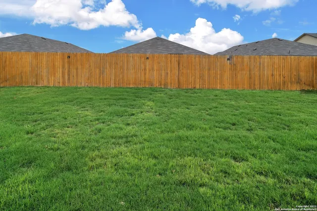 a view of backyard with a table and chair under an umbrella