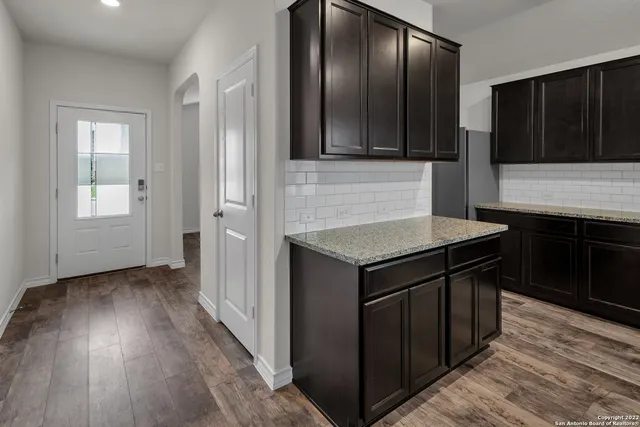 an entryway with wooden floor and cabinets