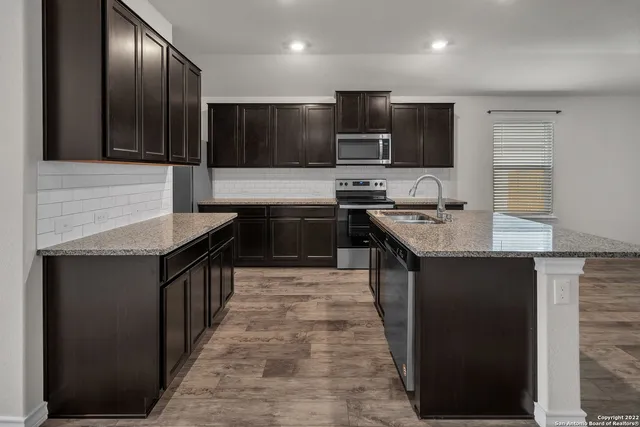 a kitchen with stainless steel appliances granite countertop a sink stove microwave and cabinets
