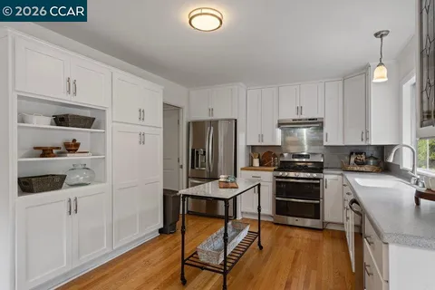 a kitchen with stainless steel appliances a stove a sink and a refrigerator