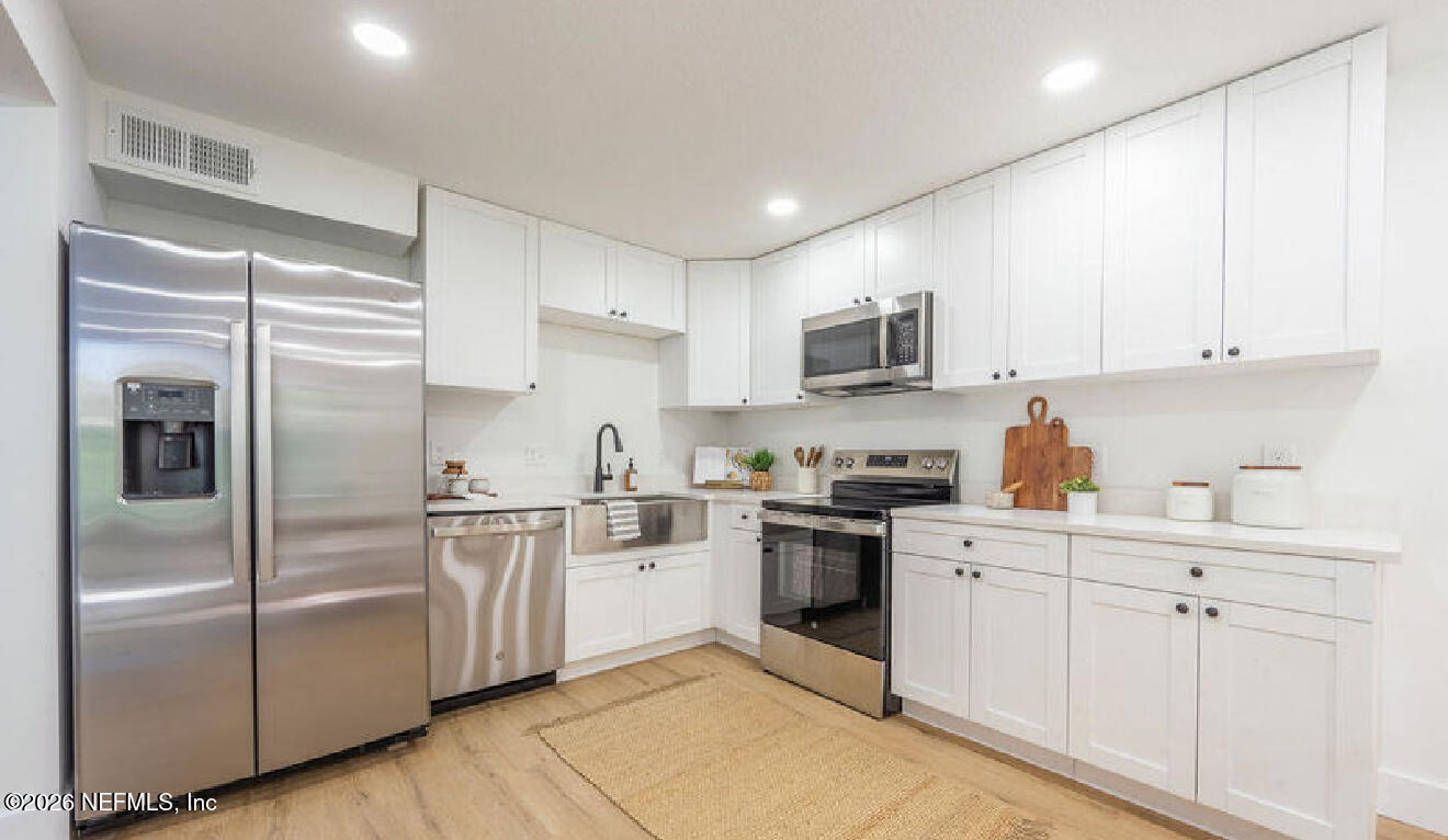 8618 Boxberry Lane Jacksonville, FL 32244 - Photo 3 of 18 a kitchen with cabinets stainless steel appliances and a window