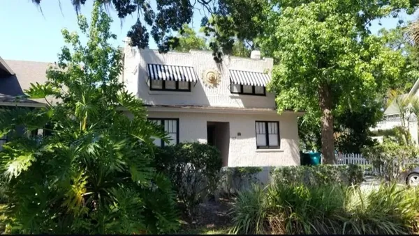a front view of a house with a tree