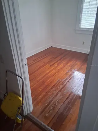 a view of a hallway with wooden floor
