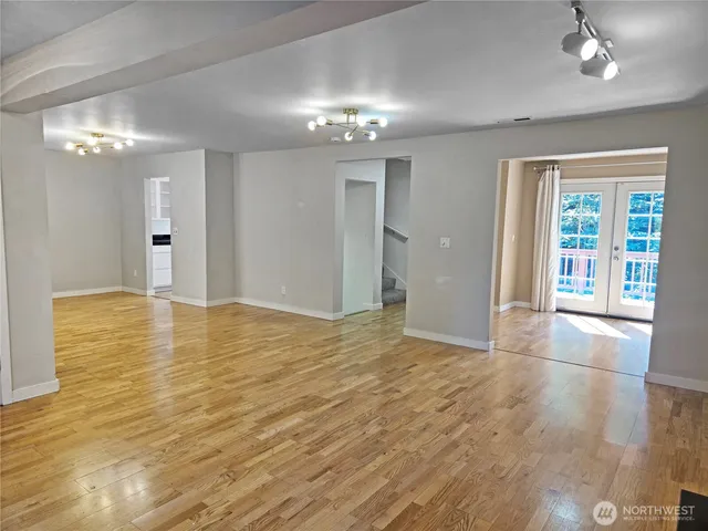 a view of an empty room and window and wooden floor