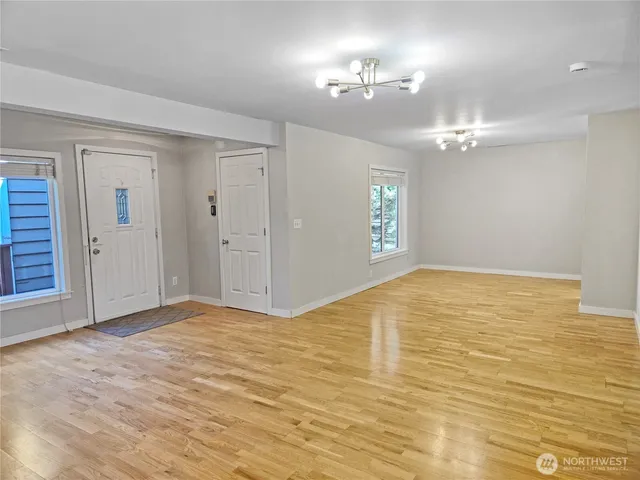 a view of a livingroom with a fireplace a chandelier and windows