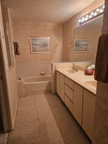 a bathroom with a tub sink and mirror