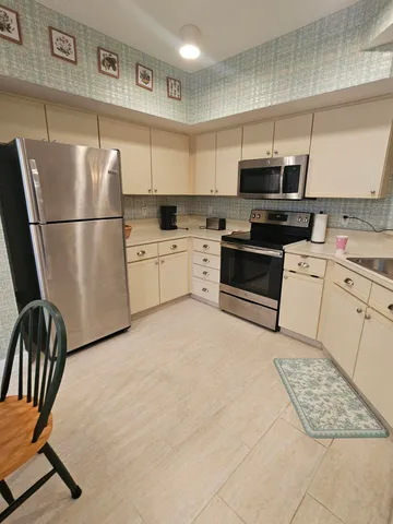 a kitchen with stainless steel appliances granite countertop a refrigerator sink and stove