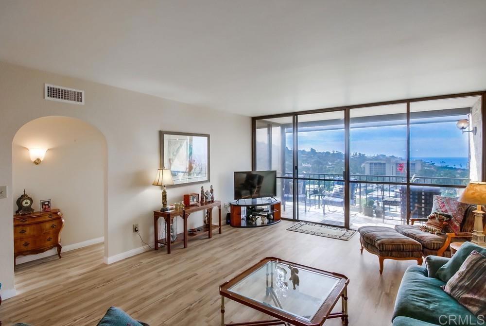 2500 Torrey Pines Road, Unit 802 La Jolla, CA 92037 - Photo 3 of 40 a living room with furniture a fireplace and a floor to ceiling window