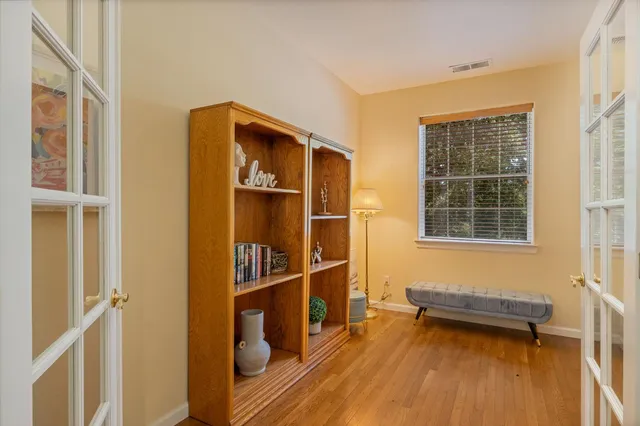a dining room with wooden floor a chandelier a wooden table and chairs