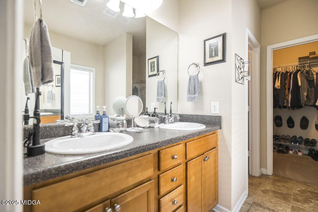 135 Abelia Lane Byron, GA 31008 - Photo 18 of 32 a bathroom with a granite countertop sink and a mirror
