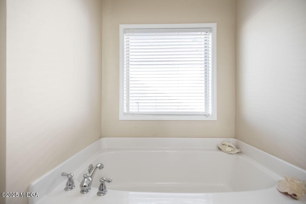 135 Abelia Lane Byron, GA 31008 - Photo 19 of 32 a white bath tub sitting in a bathroom next to a window