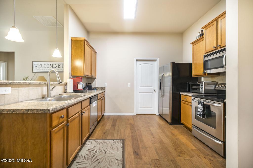 135 Abelia Lane Byron, GA 31008 - Photo 9 of 32 a kitchen with stainless steel appliances granite countertop a sink stove and refrigerator
