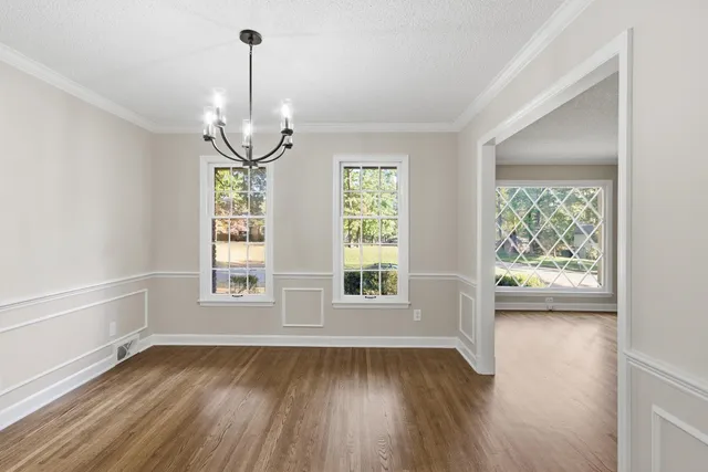 a view of empty room with wooden floor and stairs