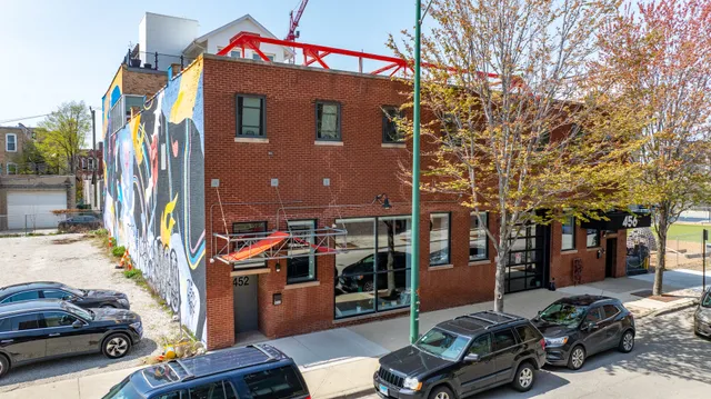 a front view of a building with parked cars