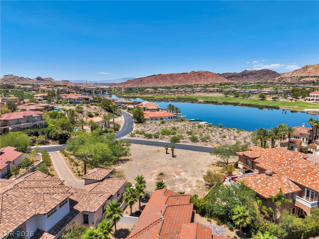 3 Rue Promenade Way Henderson, NV 89011 - Photo 9 of 26 An aerial perspective reveals a serene lake and golf course winding through a luxurious desert community.
