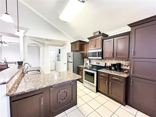 a kitchen with stainless steel appliances granite countertop a sink stove and refrigerator