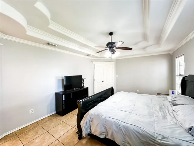 a bedroom with a bed and a flat tv screen on a dresser