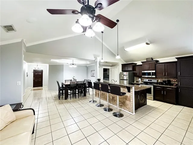 a kitchen with stainless steel appliances kitchen island granite countertop a stove and a sink