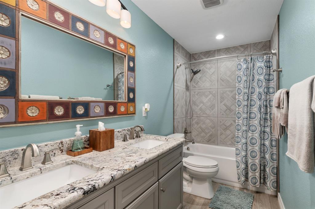 10832 Ridge Country Road Haslet, TX 76052 - Photo 21 of 30 Hall bath with beautiful tile shower surround, decorative mirror, & vanity with dual sinks & granite countertop!