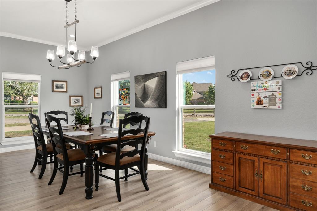 10832 Ridge Country Road Haslet, TX 76052 - Photo 5 of 30 Dining space with crown molding, a wealth of natural light, luxury vinyl plank flooring & the perfect chandelier!