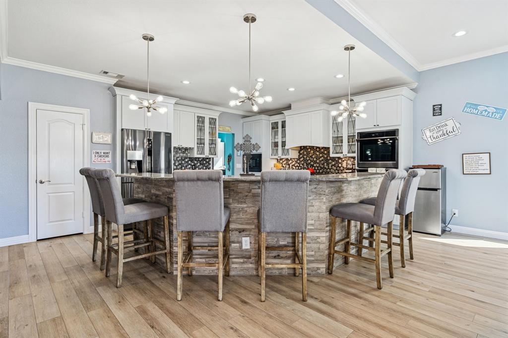 10832 Ridge Country Road Haslet, TX 76052 - Photo 7 of 30 a view of a dining room and livingroom with furniture wooden floor a chandelier