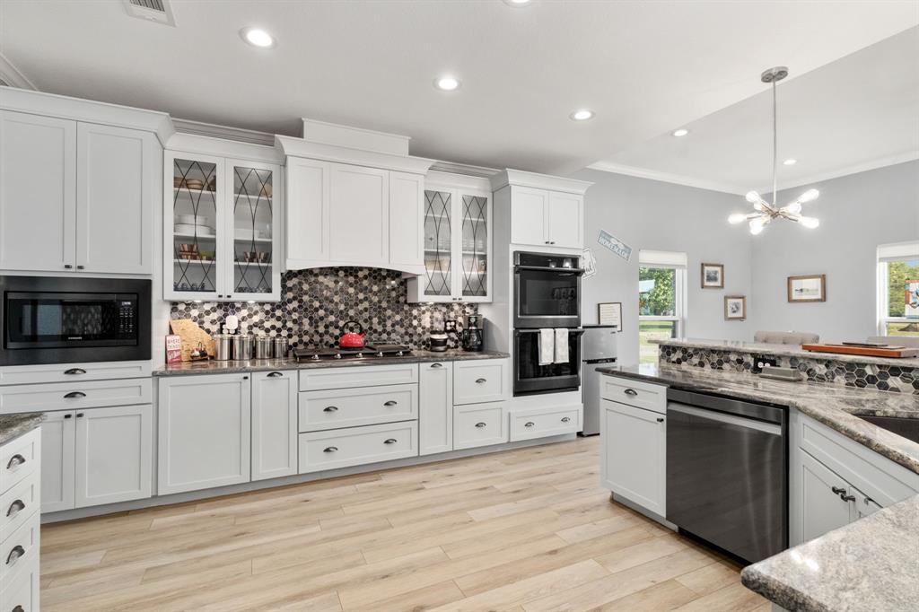 10832 Ridge Country Road Haslet, TX 76052 - Photo 9 of 30 a kitchen with stainless steel appliances kitchen island granite countertop a stove a sink and a refrigerator