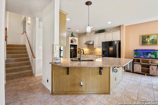 9634 Jason Bend Helotes, TX 78023 - Photo 13 of 43 a kitchen with kitchen island stainless steel appliances a stove a refrigerator a sink and a stove