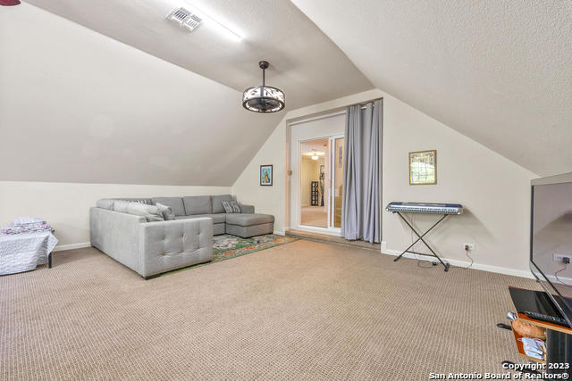 9634 Jason Bend Helotes, TX 78023 - Photo 28 of 43 a living room with furniture and a chandelier